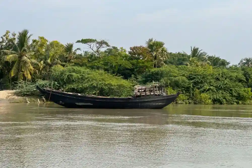 Sundarban local fisherman boat docked by riverside village showing traditional fishing life
